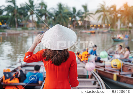 happy woman wearing Ao Dai Vietnamese dress, traveler visit Thu Bon River and Sightseeing Boat Ride at Hoi An ancient town. landmark for tourist attractions.Vietnam and Southeast travel concept happy woman wearing Ao Dai Vietnamese dress, traveler visit Thu Bon River and Sightseeing Boat Ride at Hoi An ancient town. landmark for tourist attractions.Vietnam and Southeast travel concept 98338648