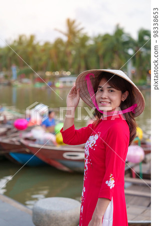happy woman wearing Ao Dai Vietnamese dress, traveler visit Thu Bon River and Sightseeing Boat Ride at Hoi An ancient town. landmark for tourist attractions.Vietnam and Southeast travel concept happy woman wearing Ao Dai Vietnamese dress, traveler visit Thu Bon River and Sightseeing Boat Ride at Hoi An ancient town. landmark for tourist attractions.Vietnam and Southeast travel concept 98338653