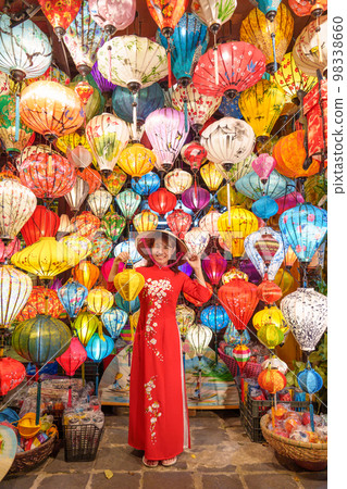 happy woman wearing Ao Dai Vietnamese dress with colorful lanterns, traveler sightseeing at Hoi An ancient town in central Vietnam.landmark for tourist attractions.Vietnam and Southeast travel concept 98338660
