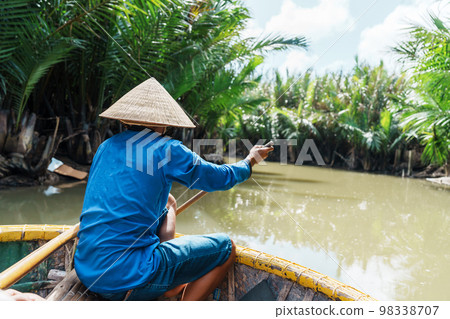 Man rowing a basket boat, along the coconut river forest, a unique Vietnamese at Cam thanh village. Landmark and popular for tourists attractions in Hoi An. Vietnam and Southeast Asia travel concepts 98338707