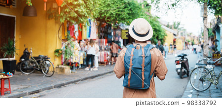 happy Solo traveler sightseeing at Hoi An ancient town in central Vietnam, man traveling with backpack and hat. landmark and popular for tourist attractions. Vietnam and Southeast Asia travel concept 98338792