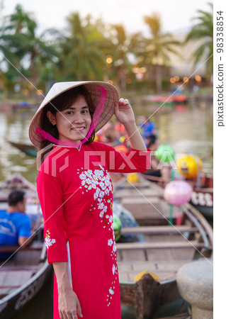 happy woman wearing Ao Dai Vietnamese dress, traveler visit Thu Bon River and Sightseeing Boat Ride at Hoi An ancient town. landmark for tourist attractions.Vietnam and Southeast travel concept 98338854
