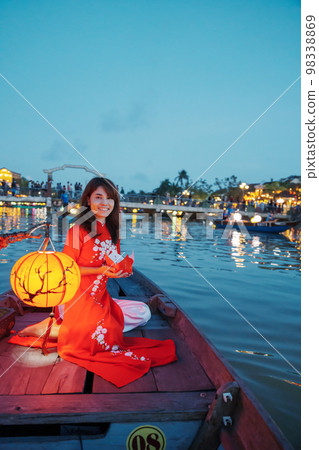 woman wearing Ao Dai Vietnamese dress, traveler Sightseeing Boat Ride and floating paper lantern at Hoi An ancient town. landmark for tourist attractions.Vietnam and Southeast travel concept woman wearing Ao Dai Vietnamese dress, traveler Sightseeing Boat Ride and floating paper lantern at Hoi An ancient town. landmark for tourist attractions.Vietnam and Southeast travel concept 98338869