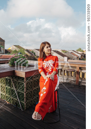 happy woman wearing Ao Dai Vietnamese dress, traveler sightseeing view at rooftop in Hoi An ancient town. landmark and popular for tourist attractions. Vietnam and Southeast travel concept 98338909