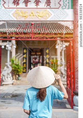 Woman traveler sightseeing at Phouc Kien Assembly hall, translation from Chinese character. The ancient grace of 300 year old architecture. Hoi An, Vietnam and Southeast Asia travel concept Woman traveler sightseeing at Phouc Kien Assembly hall, translation from Chinese character. The ancient grace of 300 year old architecture. Hoi An, Vietnam and Southeast Asia travel concept 98338914