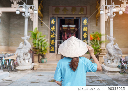 Woman traveler sightseeing at Phouc Kien Assembly hall, translation from Chinese character. The ancient grace of 300 year old architecture. Hoi An, Vietnam and Southeast Asia travel concept Woman traveler sightseeing at Phouc Kien Assembly hall, translation from Chinese character. The ancient grace of 300 year old architecture. Hoi An, Vietnam and Southeast Asia travel concept 98338915