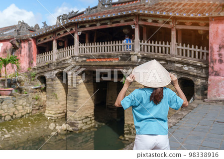 Woman traveler sightseeing at Japanese covered bridge or Cau temple in Hoi An ancient town, Vietnam. landmark and popular for tourist attractions. Vietnam and Southeast Asia travel concept Woman traveler sightseeing at Japanese covered bridge or Cau temple in Hoi An ancient town, Vietnam. landmark and popular for tourist attractions. Vietnam and Southeast Asia travel concept 98338916