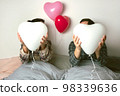 Couple of lovers holds balloons in the shape of a heart. The concept of Valentine's Day. Front view. 98339636