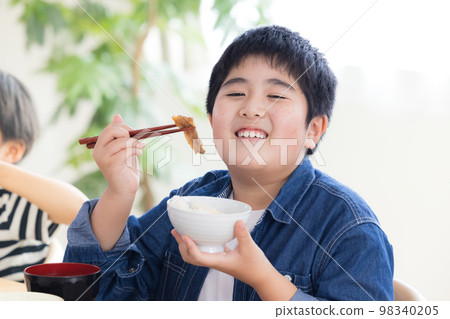 Family meal boy eating meat Family meal boy eating meat 98340205