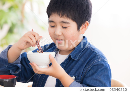 Family meal boy eating meat 98340210