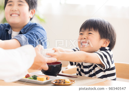 Family Meal Brothers refilling rice 98340547