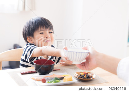 Family meal scene Boy refilling rice 98340636