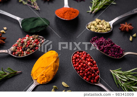 Variation of spices in metal spoons paprika, turmeric, cardamom, a mixture of allspice Variation of spices in metal spoons paprika, turmeric, cardamom, a mixture of allspice 98341009