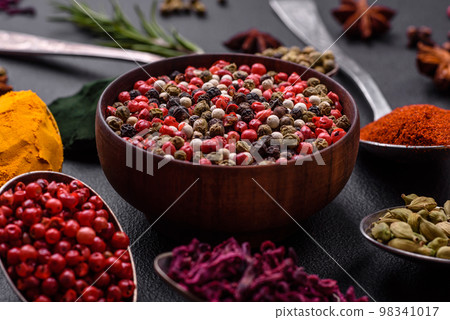 Variation of spices in metal spoons paprika, turmeric, cardamom, a mixture of allspice 98341017