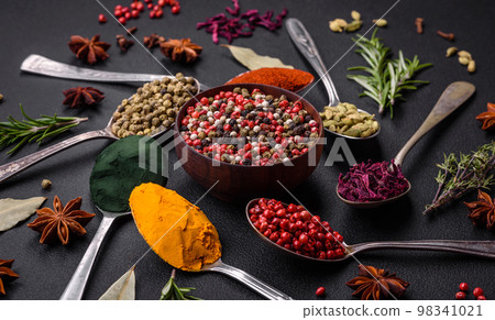 Variation of spices in metal spoons paprika, turmeric, cardamom, a mixture of allspice 98341021