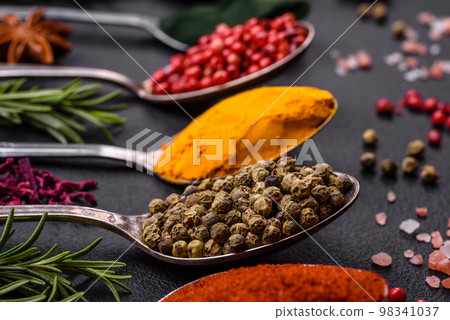 Variation of spices in metal spoons paprika, turmeric, cardamom, a mixture of allspice Variation of spices in metal spoons paprika, turmeric, cardamom, a mixture of allspice 98341037