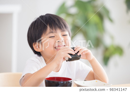 Family meal A boy eating a rice ball 98341147