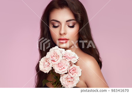 Beautiful young woman with a rose flower Beautiful young woman with a rose flower 98341670