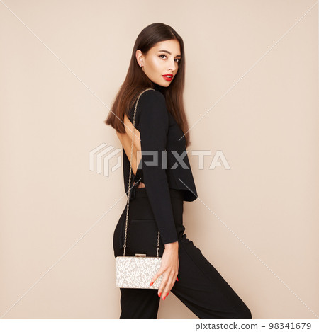 Young woman posing in a black tight suit 98341679
