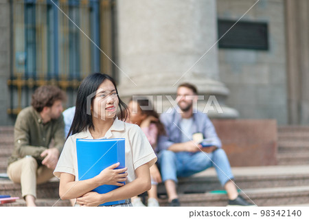 young female student standing in front of the university building. young female student standing in front of the university building. 98342140
