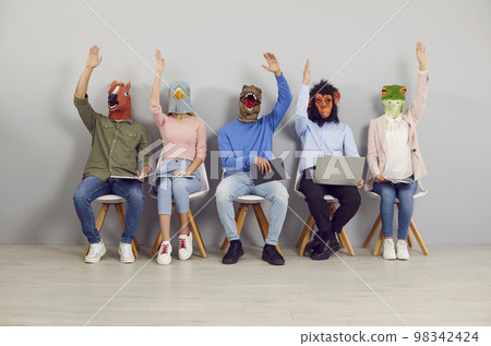 Group of people wearing funny animal masks raising their hands up to vote for a suggestion 98342424