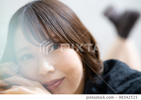 Young woman lying down and relaxing Young woman lying down and relaxing 98342515