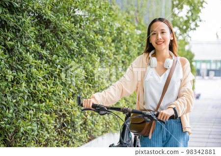 Asian young woman walking alongside with bicycle on summer in park countryside outdoor, Happy female smiling walk down the street with her bike on city road, ECO environment, healthy holiday travel Asian young woman walking alongside with bicycle on summer in park countryside outdoor, Happy female smiling walk down the street with her bike on city road, ECO environment, healthy holiday travel 98342881