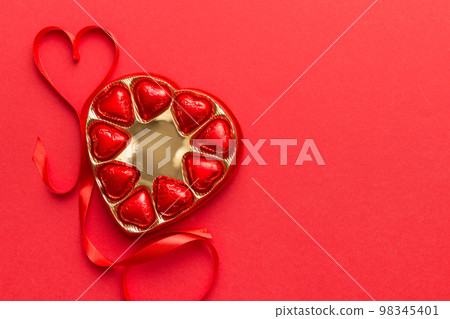 Delicious chocolate pralines in red box for Valentine's Day. Heart shaped box of chocolates top view with copy space 98345401