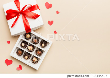 Delicious chocolate pralines in red box for Valentine's Day. Heart shaped box of chocolates top view with copy space 98345403