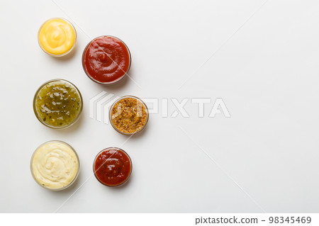 Different types of sauces in bowls on a colored Board . Top view. various sauces copy space Different types of sauces in bowls on a colored Board . Top view. various sauces copy space 98345469