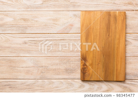 Top view of wooden cutting board on wooden background. Empty space for your design.= Top view of wooden cutting board on wooden background. Empty space for your design.= 98345477