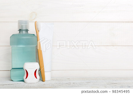 Mouthwash and other oral hygiene products on colored table top view with copy space. Flat lay. Dental hygiene. Oral care products and space for text on light background. concept 98345495