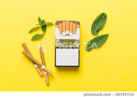 Pack of menthol cigarettes and fresh mint on colored table, Menthol cigarettes top view flat lay Pack of menthol cigarettes and fresh mint on colored table, Menthol cigarettes top view flat lay 98345550