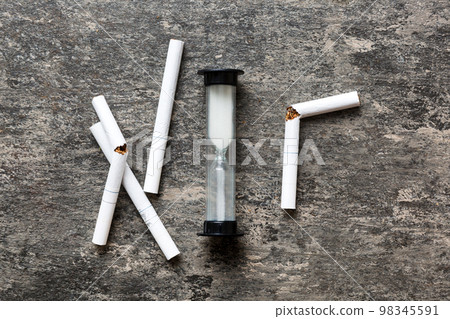 Broken cigarette on table background , No Tobacco Day with hourglass, clock health concept. time to quit smoking 98345591