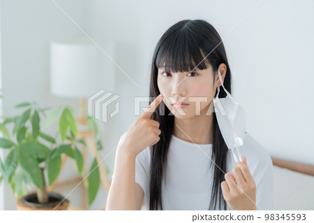 Z generation girl who wears a mask on her ear and cares about her skin condition Z generation girl who wears a mask on her ear and cares about her skin condition 98345593