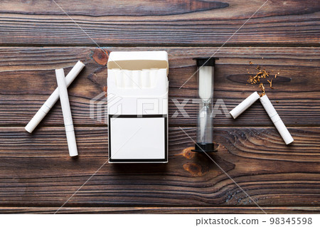 Broken cigarette on table background , No Tobacco Day with hourglass, clock health concept. time to quit smoking 98345598