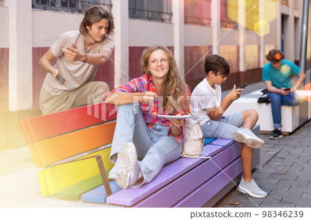 Teens hanging out outdoors 98346239