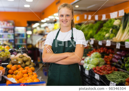 Pretty young saleswoman posing at grocery 98346304
