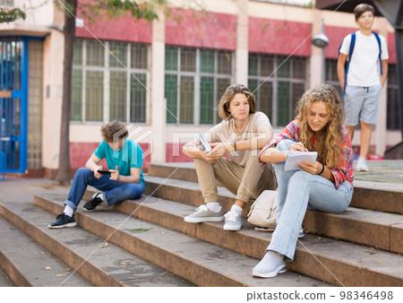Teenagers on stairs beside of school 98346498