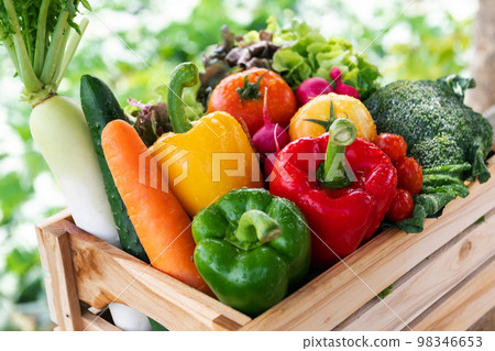 Wooden crate filled with fresh organic vegetables . Wooden crate filled with fresh organic vegetables . 98346653