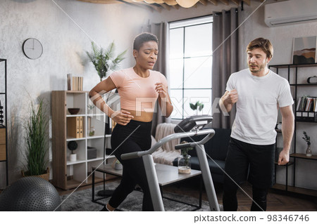 Portrait of focused young african female wearing sportswear and using treadmill 98346746