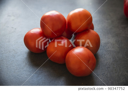 red tomatoes on a dark kitchen counter red tomatoes on a dark kitchen counter 98347752