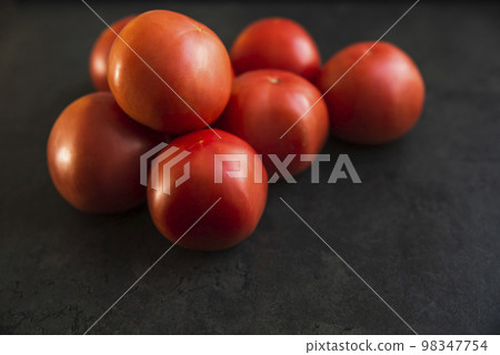 red tomatoes on a dark kitchen counter red tomatoes on a dark kitchen counter 98347754