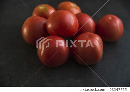 red tomatoes on a dark kitchen counter 98347755