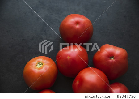 red tomatoes on a dark kitchen counter red tomatoes on a dark kitchen counter 98347756