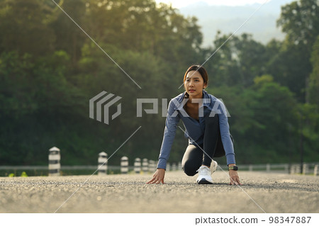 Young sportswoman in starting position, Make effort for victory, Fitness, sport and healthy lifestyle concept Young sportswoman in starting position, Make effort for victory, Fitness, sport and healthy lifestyle concept 98347887