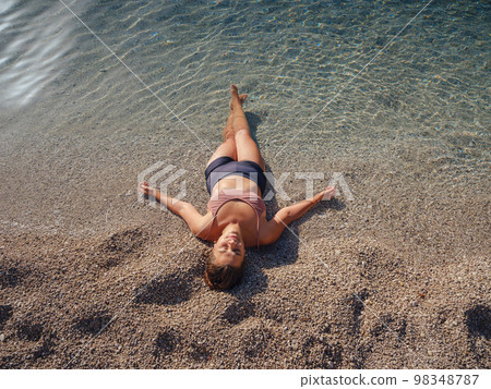 Cheerful woman enjoying the beach 98348787