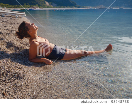 Cheerful woman enjoying the beach Cheerful woman enjoying the beach 98348788