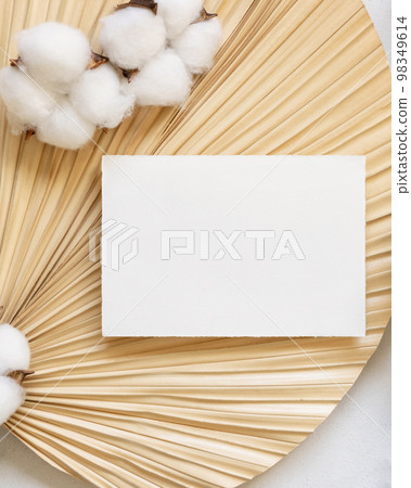 Blank card on dried palm leaf with cotton flowers top view, wedding mockup 98349614