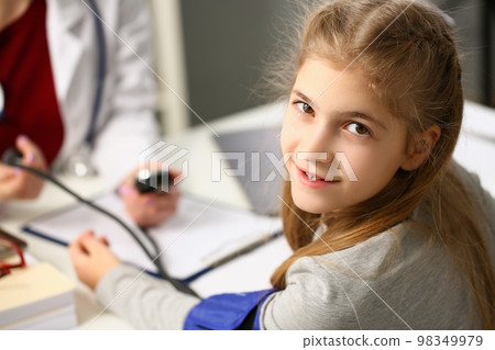 Doctor measures pressure of girl child in clinic Doctor measures pressure of girl child in clinic 98349979